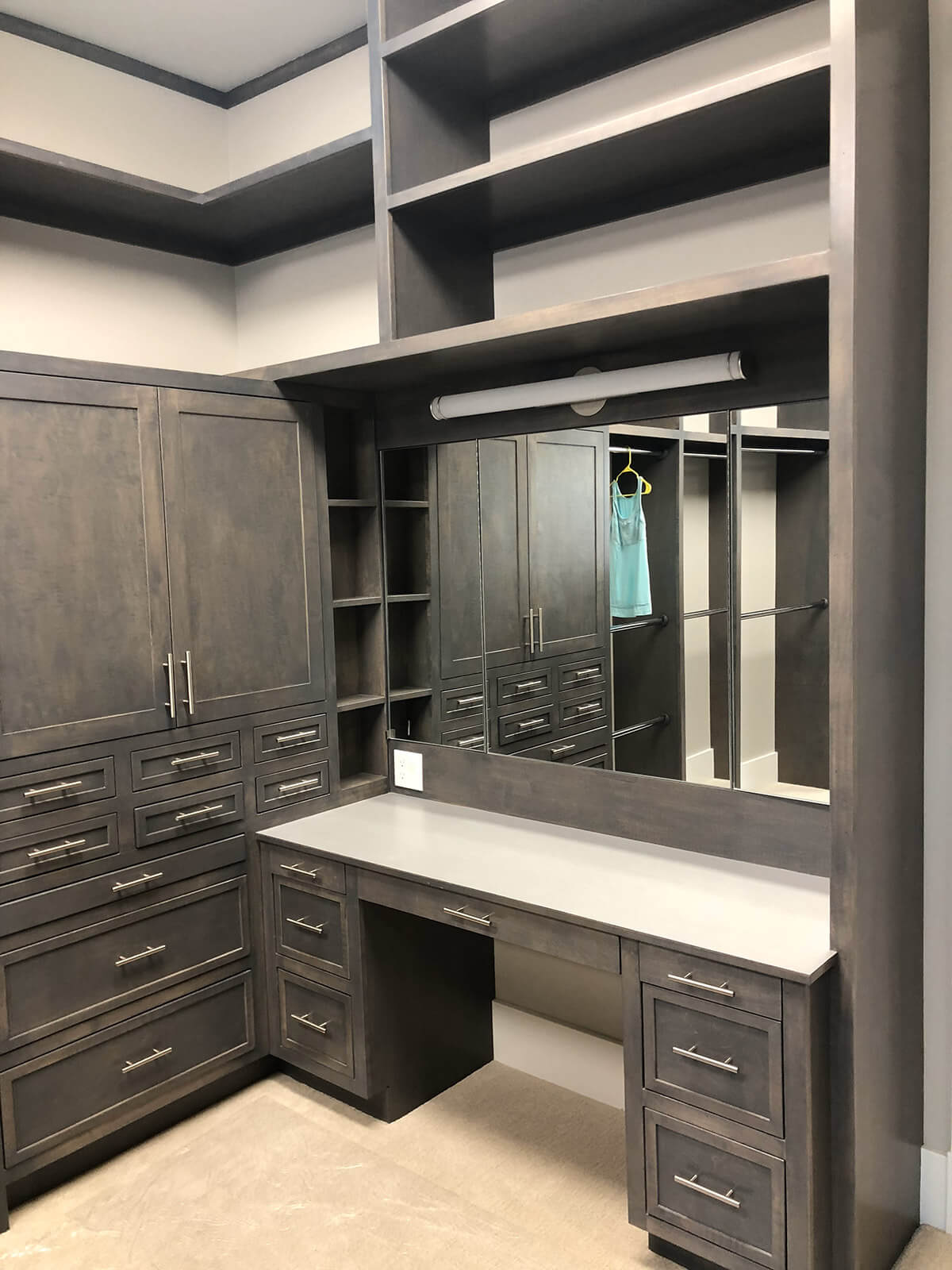 Large closet with many cabinets and a vanity.