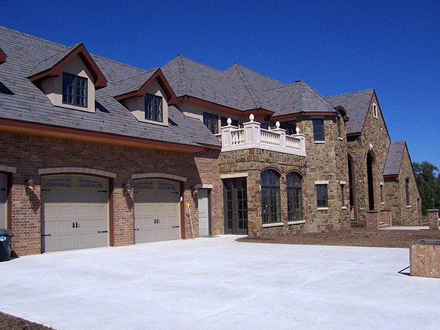 Exterior view of custom home with brick and stone exterior.